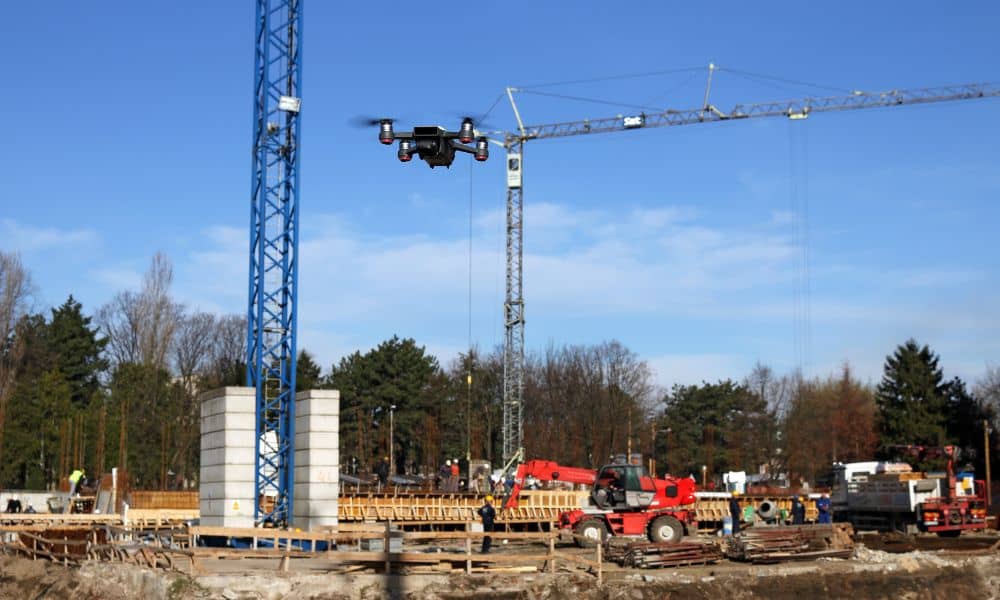 Drone surveying construction site - ALTA SURVEY South Carolina Professional drone surveying an active construction site with cranes and workers, collecting aerial data for engineering and land surveying projects.