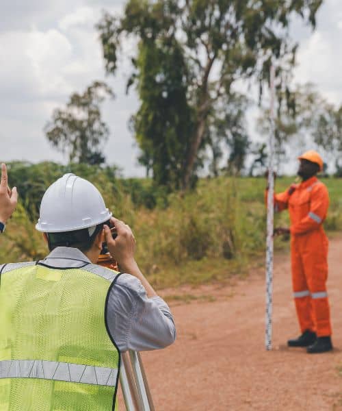 Land surveyor working construction staking survey - ALTA SURVEY South Carolina Land surveyor using tripod equipment to measure ground levels during a construction staking survey