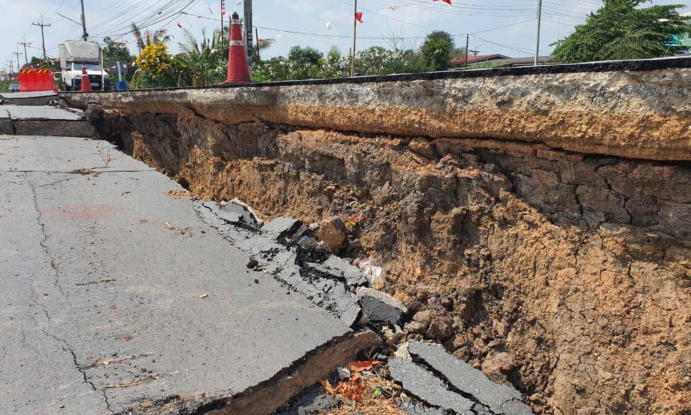 Sinkhole road collapse - ALTA SURVEY South Carolina Large road sinkhole showing collapsed pavement and exposed soil layers, highlighting the need for a construction staking survey