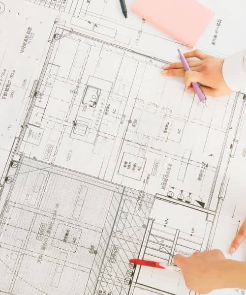 Team reviewing building blueprints to prepare for a construction survey