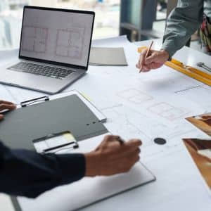 Professionals reviewing construction plans and blueprints for construction surveys to ensure accurate project execution
