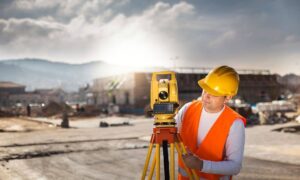 A licensed land surveyor performing construction surveys on an active construction site