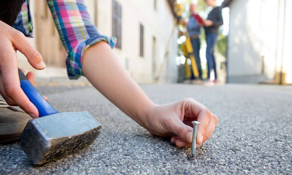 A residential surveyor placing a property boundary marker near a home