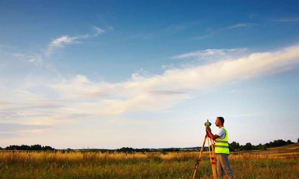 Licensed land surveyor measuring property boundaries after rezoning changes