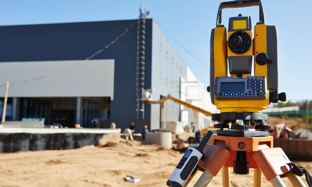 Surveying instrument set up at a construction site to measure and document conditions for an as-built survey